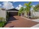Charming single-Gathering home with a brown two-car garage and brick paved driveway lined with tropical landscaping at 13511 Avista Dr, Tampa, FL 33624