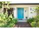 Beautiful front entrance featuring a blue door, brick pathway, and lush landscaping at 13511 Avista Dr, Tampa, FL 33624