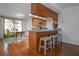 Eat-in kitchen with breakfast bar, hardwood floors, light wood cabinets, and dining table in the background at 13511 Avista Dr, Tampa, FL 33624