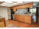 An eat-in kitchen with stainless steel appliances, wood cabinets, hardwood floors, and stone countertops at 13511 Avista Dr, Tampa, FL 33624