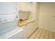 Well-lit laundry room features a sink, counter space, white cabinets, and stacked washer/dryer unit at 13511 Avista Dr, Tampa, FL 33624