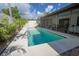 Inviting in-ground pool with a ladder, surrounded by a concrete patio and lush landscaping at 13511 Avista Dr, Tampa, FL 33624