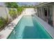 Backyard features a rectangular pool surrounded by lush landscaping, providing a private outdoor oasis at 13511 Avista Dr, Tampa, FL 33624