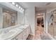 Bright bathroom with double vanity sinks, walk-in shower, and a view of the walk-in closet at 13822 Harvestwood Ln, Riverview, FL 33569