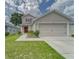 Charming two-story home with a well-manicured lawn, showcasing its inviting curb appeal and attached two car garage at 13822 Harvestwood Ln, Riverview, FL 33569
