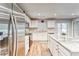 A well-lit kitchen with white cabinets, a center island with barstools, and stainless steel appliances at 13822 Harvestwood Ln, Riverview, FL 33569