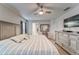 A serene primary bedroom featuring a ceiling fan, neutral decor, and an en-suite bathroom entrance at 13822 Harvestwood Ln, Riverview, FL 33569