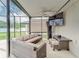 Enclosed patio featuring comfortable wicker furniture, a ceiling fan, and a mounted television at 13822 Harvestwood Ln, Riverview, FL 33569