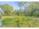 Beautiful landscaped backyard featuring mature trees and lush green lawn at 13934 Clubhouse Cir # 8, Tampa, FL 33618