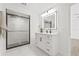 This bathroom features a walk-in shower, white cabinets and a large lighted mirror at 13934 Clubhouse Cir # 8, Tampa, FL 33618