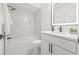 Updated bathroom featuring a shower over the tub, a marble tile surround, and a modern vanity at 13934 Clubhouse Cir # 8, Tampa, FL 33618