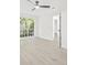 Bright bedroom featuring a ceiling fan, light wood floors, and a window with a garden view at 13934 Clubhouse Cir # 8, Tampa, FL 33618