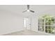 A bright bedroom showcasing a ceiling fan, modern light wood flooring and a window with garden views at 13934 Clubhouse Cir # 8, Tampa, FL 33618