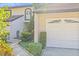 Attached garage featuring decorative windows and complemented by meticulously maintained landscaping at 13934 Clubhouse Cir # 8, Tampa, FL 33618