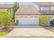 Exterior image of a two-car garage with a concrete driveway, lush landscaping, and clear house number at 13934 Clubhouse Cir # 8, Tampa, FL 33618