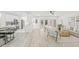 Open-concept living room featuring light wood floors, a ceiling fan, and a modern kitchen in the background at 13934 Clubhouse Cir # 8, Tampa, FL 33618