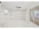 Bright living room with built-in bookshelves, a ceiling fan, and large windows at 13934 Clubhouse Cir # 8, Tampa, FL 33618