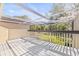 Screened patio with wooden railing overlooks grassy area with mature trees at 13934 Clubhouse Cir # 8, Tampa, FL 33618