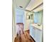 Bathroom with single sink vanity, large mirror, and wood-look flooring at 141 Lakeside Dr, Oldsmar, FL 34677