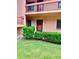 Inviting condo entrance showcasing well-maintained lawn and colorful hibiscus for a warm welcome at 141 Lakeside Dr, Oldsmar, FL 34677