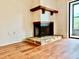 Close up of the fireplace with wood floors and screened patio at 141 Lakeside Dr, Oldsmar, FL 34677
