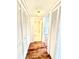 Hallway with white closet doors, wood flooring, and bathroom view at 141 Lakeside Dr, Oldsmar, FL 34677