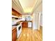 Practical kitchen with wooden cabinets, modern appliances, a pass-through and wood-look flooring at 141 Lakeside Dr, Oldsmar, FL 34677
