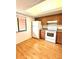 Bright kitchen with white appliances, wooden cabinets, and wood-look flooring, awaiting culinary adventures at 141 Lakeside Dr, Oldsmar, FL 34677
