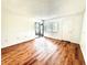 Bright living room featuring wood-look flooring, neutral walls, and a sliding glass door to the patio at 141 Lakeside Dr, Oldsmar, FL 34677