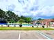 Community pool featuring a safety fence, surrounding lush greenery, lounge chairs, and a refreshing swimming space at 141 Lakeside Dr, Oldsmar, FL 34677
