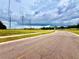 Paved road under a cloudy sky, featuring grassy terrain, distant power lines and a scenic view at 141 Lakeside Dr, Oldsmar, FL 34677