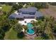 Expansive property featuring a large pool with spa, lush landscaping, and a well-maintained lawn, as seen from above at 17129 Breeders Cup Dr, Odessa, FL 33556