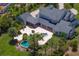 Aerial view of a luxury home featuring a pool, hot tub and a lush tropical garden setting at 17129 Breeders Cup Dr, Odessa, FL 33556