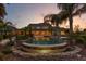 Stunning backyard pool area with a spa and lush landscaping at twilight, creating a serene oasis at 17129 Breeders Cup Dr, Odessa, FL 33556