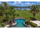 Stunning aerial view of a private pool and expansive lawn leading to a picturesque lake at 17129 Breeders Cup Dr, Odessa, FL 33556