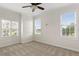 A bright, empty bedroom with neutral carpet, three windows, and crown molding for a comfortable atmosphere at 17129 Breeders Cup Dr, Odessa, FL 33556