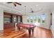 Spacious billiard room featuring beautiful views, ample lighting, a wet bar, and hardwood floors at 17129 Breeders Cup Dr, Odessa, FL 33556