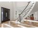 Inviting foyer featuring a curved staircase, stone floors, and elegant wood front door at 17129 Breeders Cup Dr, Odessa, FL 33556