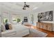 Bright main bedroom featuring tray ceilings, hardwood floors, and a seating area at 17129 Breeders Cup Dr, Odessa, FL 33556