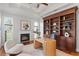 Elegant home office with custom built-ins, a fireplace, and tray ceilings at 17129 Breeders Cup Dr, Odessa, FL 33556