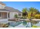 A stunning backyard pool with stone accents and lush tropical landscaping, perfect for relaxation at 17129 Breeders Cup Dr, Odessa, FL 33556