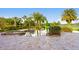 Beautiful backyard with a luxurious pool and spa, surrounded by tropical plants, and a lake view at 17129 Breeders Cup Dr, Odessa, FL 33556