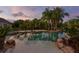 A luxurious pool with palm trees reflecting in the water creates an inviting backyard oasis at 17129 Breeders Cup Dr, Odessa, FL 33556