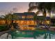 An inviting pool area with palm trees reflects in the water creating a serene backyard retreat at 17129 Breeders Cup Dr, Odessa, FL 33556