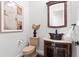 Stylish powder room featuring a vanity with a unique vessel sink and elegant mirror at 17129 Breeders Cup Dr, Odessa, FL 33556