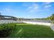 Expansive backyard with lush lawn, white fence, and serene lake views at 1726 Hadden Hall Pl, Trinity, FL 34655