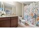 Bathroom with granite countertop vanity, floral shower curtain and neutral tiling at 1726 Hadden Hall Pl, Trinity, FL 34655