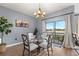 Bright dining room with modern chandelier, glass table, and sliding glass doors to the backyard at 1726 Hadden Hall Pl, Trinity, FL 34655