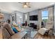 This living room features hardwood floors, large windows, ceiling fan and a comfortable lounging area at 1726 Hadden Hall Pl, Trinity, FL 34655