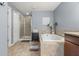 Ensuite bath with tile flooring, soaking tub, glass-enclosed shower, and linen closet at 1726 Hadden Hall Pl, Trinity, FL 34655